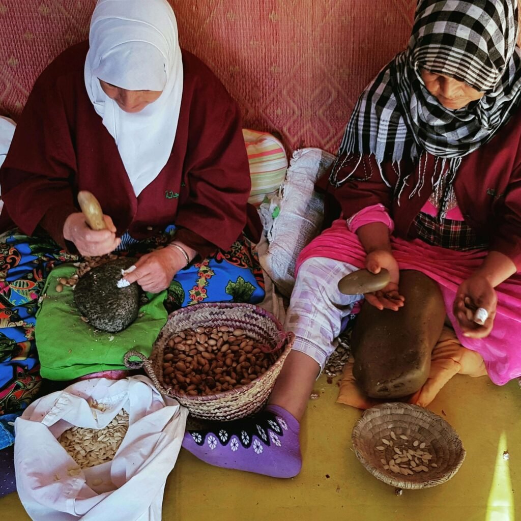 Femmes marocaines décortiquant les noix d’argan à la main avec des pierres