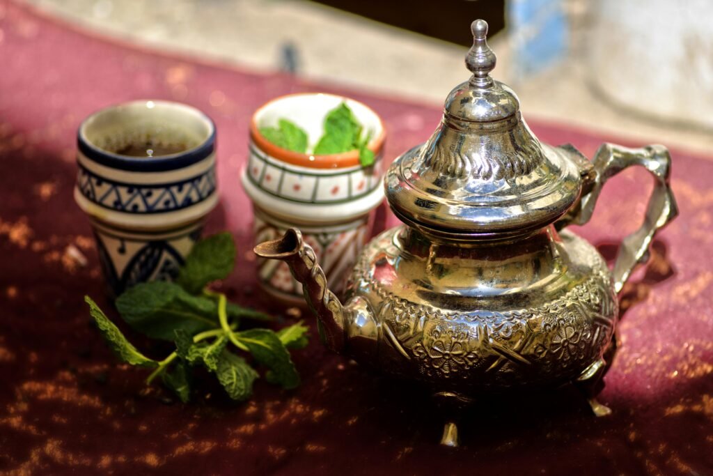 Menthe séchée et théière marocaine utilisées pour préparer le thé traditionnel servi lors des moments de partage au Maroc